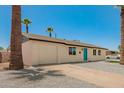 Inviting single-story home featuring a blue door, with manicured stone landscaping and tall palm trees at 3302 N 40Th Dr, Phoenix, AZ 85019