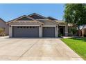 Inviting single-story home with a spacious three-car garage, tidy landscaping, and a well-maintained lawn at 34970 N Spur Cir, San Tan Valley, AZ 85144