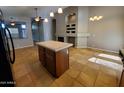 Open-concept living space with kitchen island, fireplace, tile flooring and a neutral color palette at 351 S Apache Dr, Chandler, AZ 85224