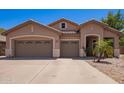 Charming single-story home featuring a three-car garage, desert landscaping, and neutral stucco facade at 3823 E Kroll Dr, Gilbert, AZ 85234