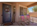 Inviting front porch with rocking chairs, decorative wreath, and a cozy welcome mat at 3823 E Kroll Dr, Gilbert, AZ 85234