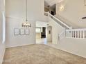 Bright living room features a modern chandelier, high ceilings and staircase leading to the second level at 4002 E Agave Rd, Phoenix, AZ 85044