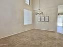 Bright living room featuring high ceilings, modern chandelier, and large window with natural light at 4002 E Agave Rd, Phoenix, AZ 85044