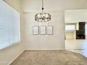 Bright living room with large window and a modern chandelier with views into another room at 4002 E Agave Rd, Phoenix, AZ 85044