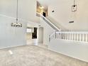 Spacious living room with neutral carpet, chandelier, staircase, and an inviting open layout at 4002 E Agave Rd, Phoenix, AZ 85044