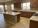 Spacious kitchen with an island, wooden cabinets, stainless steel appliances, and large windows at 5345 W Marcus Dr, Phoenix, AZ 85083