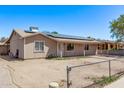 Single-story home featuring solar panels, fenced front yard, neutral paint, and covered entry at 6814 W Berkeley Rd, Phoenix, AZ 85035