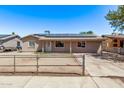 Single-story home featuring solar panels, fenced front yard, neutral paint, and covered entry at 6814 W Berkeley Rd, Phoenix, AZ 85035