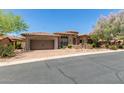 Charming stone home featuring a tile roof, two-car garage, and beautiful landscaping at 7134 E Sandia St, Mesa, AZ 85207