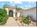 Charming front exterior with a courtyard, manicured landscaping and architectural details at 7214 E Royal Palm Rd, Scottsdale, AZ 85258