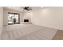 Open living room with fireplace, sliding glass doors to patio, and neutral carpet at 8301 N 21St Dr # F102, Phoenix, AZ 85021