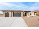 Beautiful single-story home featuring a stone facade, desert landscaping, and a spacious three-car garage at 9626 E Bunny Ear E Ln, Gold Canyon, AZ 85118