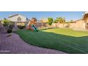 Spacious backyard with artificial turf, play structure, and low-maintenance landscaping at 10822 W Quail Ave, Peoria, AZ 85373