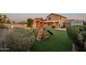 Lush backyard with artificial turf, play structure, and a covered patio perfect for outdoor fun at 10822 W Quail Ave, Peoria, AZ 85373