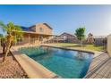 Sparkling pool in a private backyard with lush greenery, a play structure, and secure fencing at 10822 W Quail Ave, Peoria, AZ 85373