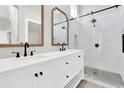 Bathroom featuring double vanity, wooden framed mirrors, white shaker cabinets and a walk-in glass shower at 1350 S Greenfield Rd # 1166, Mesa, AZ 85206