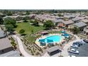 Aerial view of community pool with cabanas, lounge chairs, and well-manicured landscaping near residential homes at 1350 S Greenfield Rd # 1166, Mesa, AZ 85206