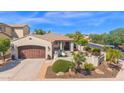 Beautiful home featuring a well-manicured lawn, desert landscaping, and a two-car garage at 1462 E Sweet Citrus Dr, Queen Creek, AZ 85140