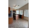 The kitchen features wood cabinetry, island, tile floors, and stainless steel appliances at 1546 W Vaughn Ave, Gilbert, AZ 85233