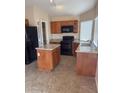 The kitchen features wood cabinetry, island, tile floors, and stainless steel appliances at 1546 W Vaughn Ave, Gilbert, AZ 85233