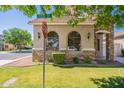 Home exterior with arched windows, green grass, meticulous landscaping, and street sign at 1851 E Ellis St, Phoenix, AZ 85042