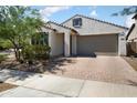 Single-Gathering home with a welcoming facade, a brick driveway, and well-maintained landscaping at 20644 W Mariposa St, Buckeye, AZ 85396