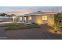 Well-lit single story home with gravel landscaping and green lawn squares at 2129 W Indianola Ave, Phoenix, AZ 85015