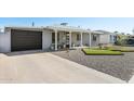 Quaint single-story home with a brown garage door and modern, minimalist landscaping at 2129 W Indianola Ave, Phoenix, AZ 85015
