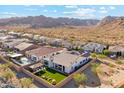 Serene backyard featuring an outdoor kitchen, a pool, and a mountain range backdrop, perfect for relaxation and entertainment at 21391 W Mariposa St, Buckeye, AZ 85396