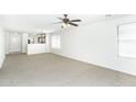 Bright and airy living room with neutral carpet, ceiling fan, and generous natural light at 2174 W Kristina Ave, San Tan Valley, AZ 85144