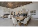 Open-concept dining and living spaces with modern light fixtures, wood plank ceilings, and view into modern kitchen at 24863 N 103Rd Way, Scottsdale, AZ 85255
