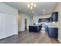Open floor plan showcasing a kitchen with a stainless-steel fridge, center island and dark cabinetry at 25602 W Coles Rd, Buckeye, AZ 85326