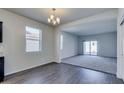 Bright, open-concept living room with wood floors, and a view into the living area with carpet at 25602 W Coles Rd, Buckeye, AZ 85326
