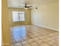 Spacious living area features neutral walls, tiled flooring, a window, and a ceiling fan at 3121 W Laurie Ln, Phoenix, AZ 85051