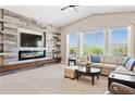 Bright living room featuring a vaulted ceiling, a modern fireplace, and large windows at 31320 N 54Th Pl, Cave Creek, AZ 85331