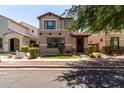 A tan two-story home features manicured landscaping, and a welcoming facade at 3449 E Sheffield Rd, Gilbert, AZ 85296