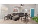 Inviting living room featuring a plush gray sectional, wood-look tile floors, and a view of the backyard at 3668 E Derringer Way, Gilbert, AZ 85297