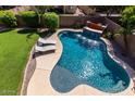 Aerial view of a backyard featuring a private pool with waterfall, lounge chairs, and lush landscaping at 3693 E Sparrow Pl, Chandler, AZ 85286