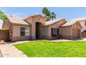 Charming single-story home features a lush lawn, desert landscaping, and covered entry at 423 W Century Ct, Gilbert, AZ 85233