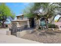 Charming two-story home features a tile roof, arched entryway, three-car garage and gated courtyard at 4530 E White Feather Ln, Cave Creek, AZ 85331