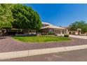 Attractive home with mature trees, lush lawn, and a convenient three-car garage at 4648 W Misty Willow Ln, Glendale, AZ 85310