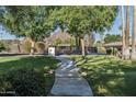 Lush front lawn with mature trees and a charming walkway leading to a private residence at 5112 N 41St St, Phoenix, AZ 85018