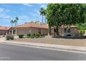 Inviting single-story home featuring mature trees, desert landscaping, and a tile roof at 5758 E Fox St, Mesa, AZ 85205