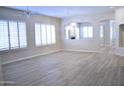 Bright living room with wood-look tile floors, a ceiling fan, and white shutters at 7979 E Princess Dr # 8, Scottsdale, AZ 85255