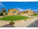 Charming single-story home with stucco and tile roof, complimented by desert landscaping and manicured lawn at 8298 E Tailfeather Dr, Scottsdale, AZ 85255