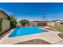 Sunny backyard featuring a sparkling pool with clear blue water and landscaped surroundings at 844 E Ruth Ave, Phoenix, AZ 85020
