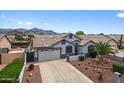 Beautiful single-Gathering home with desert landscaping, a well-maintained lawn, and a two-car garage at 8776 E Brilliant Sky Cir, Gold Canyon, AZ 85118