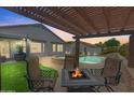 Cozy outdoor patio with a pergola, fire pit, and seating area near the pool, perfect for entertaining at 8776 E Brilliant Sky Cir, Gold Canyon, AZ 85118
