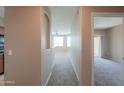 Hallway leading to living area with carpeted floors and neutral colored walls at 9820 N Central Ave # 212, Phoenix, AZ 85020