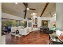 Cozy living room with a fireplace, wood floors, and expansive windows offering scenic views at 10638 E Honey Mesquite Dr, Scottsdale, AZ 85262